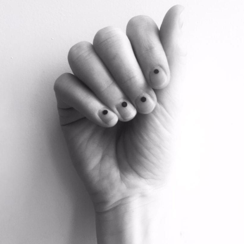 A hand with a nail tattoo by Needle Nails.