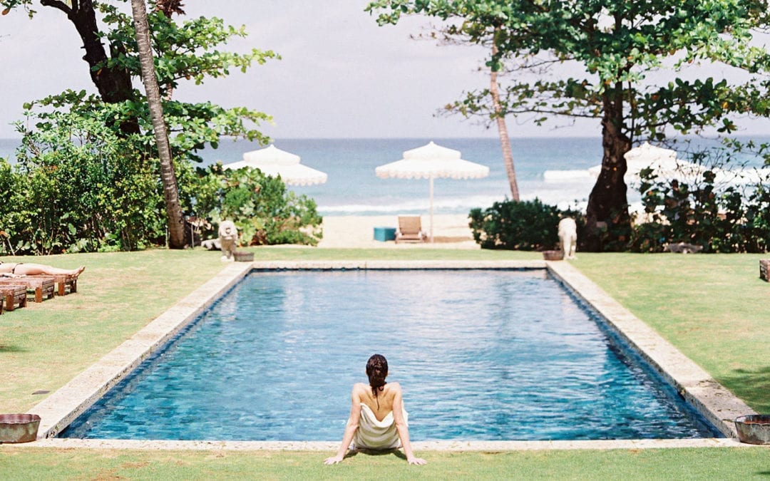 A woman relaxing by a pool at The Retreatment, a wellness retreat in the Dominican Republic.
