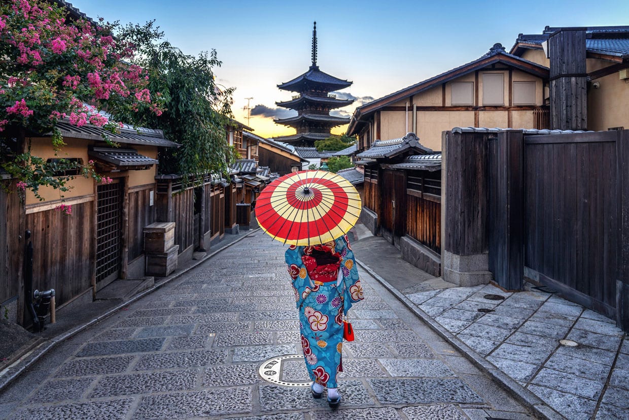 A woman wearing a traditional Japanese kimono with umbrella at Yasaka Pagoda and Sannen Zaka Street in Kyoto, Japan.