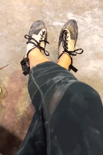 An animated gif of a woman with rock climbing shoes moving her feet.