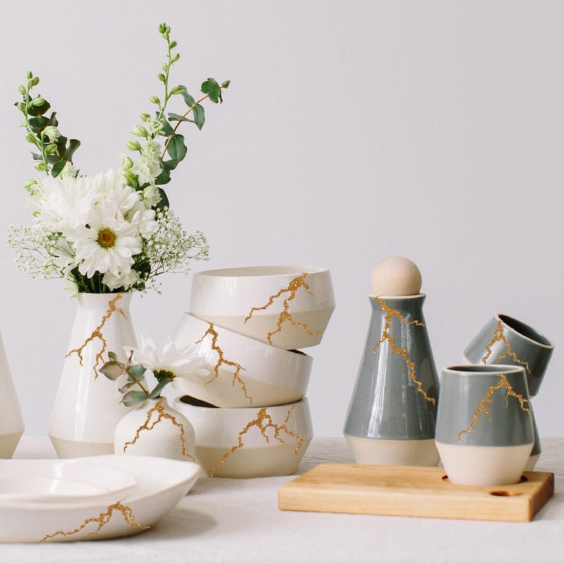 An animated photo of various ceramic plates, cups and vases with growing cracks made of glitter.