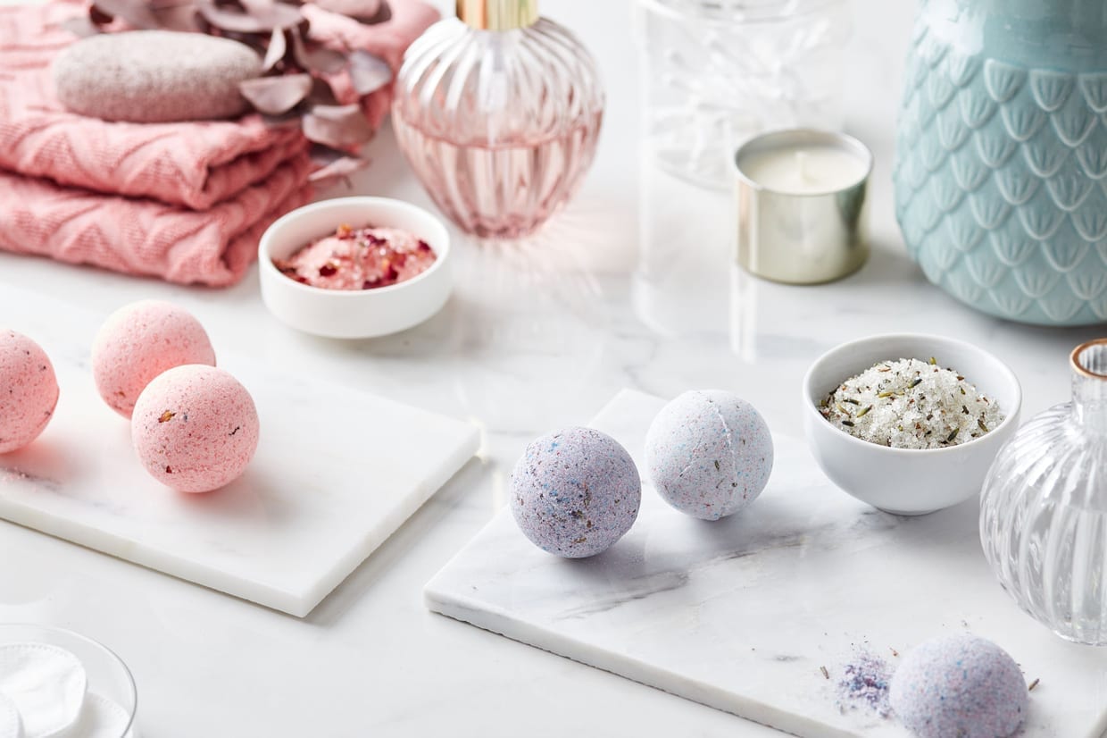 Still life of colorful bath bombs on marble boards.