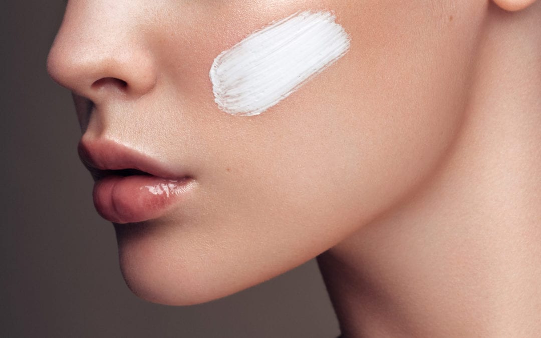A woman applying skincare products.