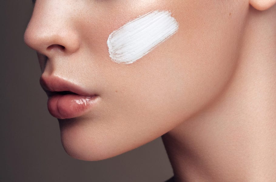 A woman applying skincare products.