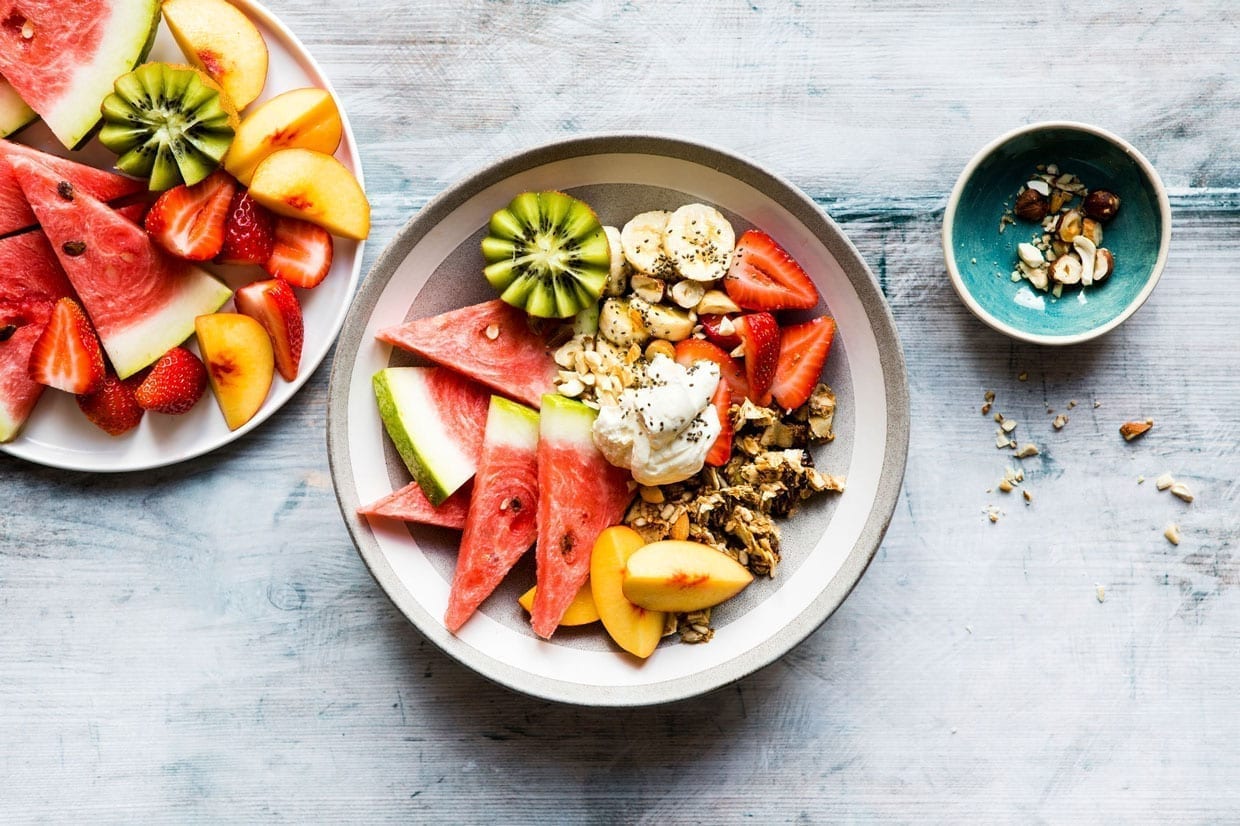 Overhead shot of a breakfast bowl with fruit and granola.
