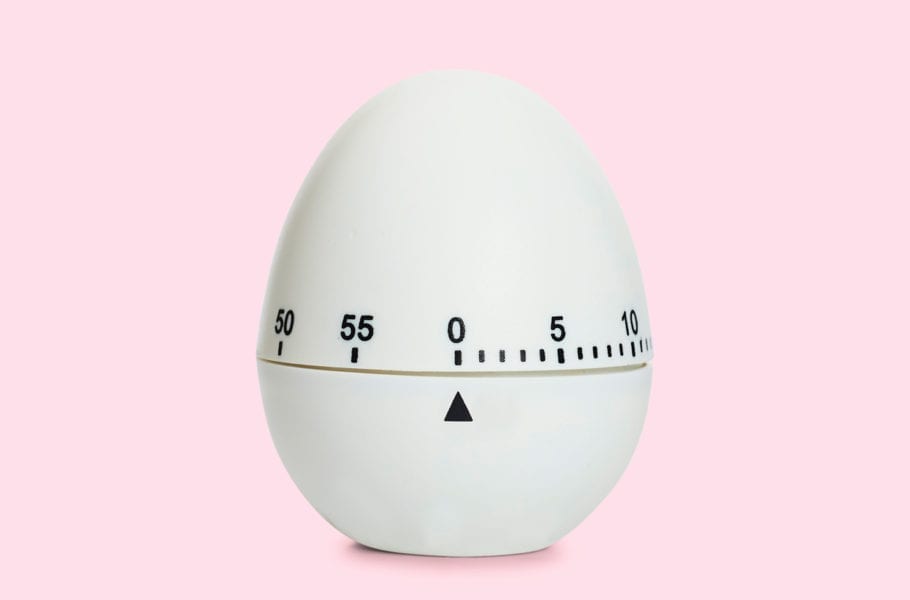An egg timer on a pink background.