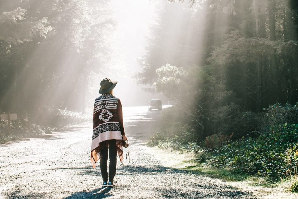 A woman walking in a forest.