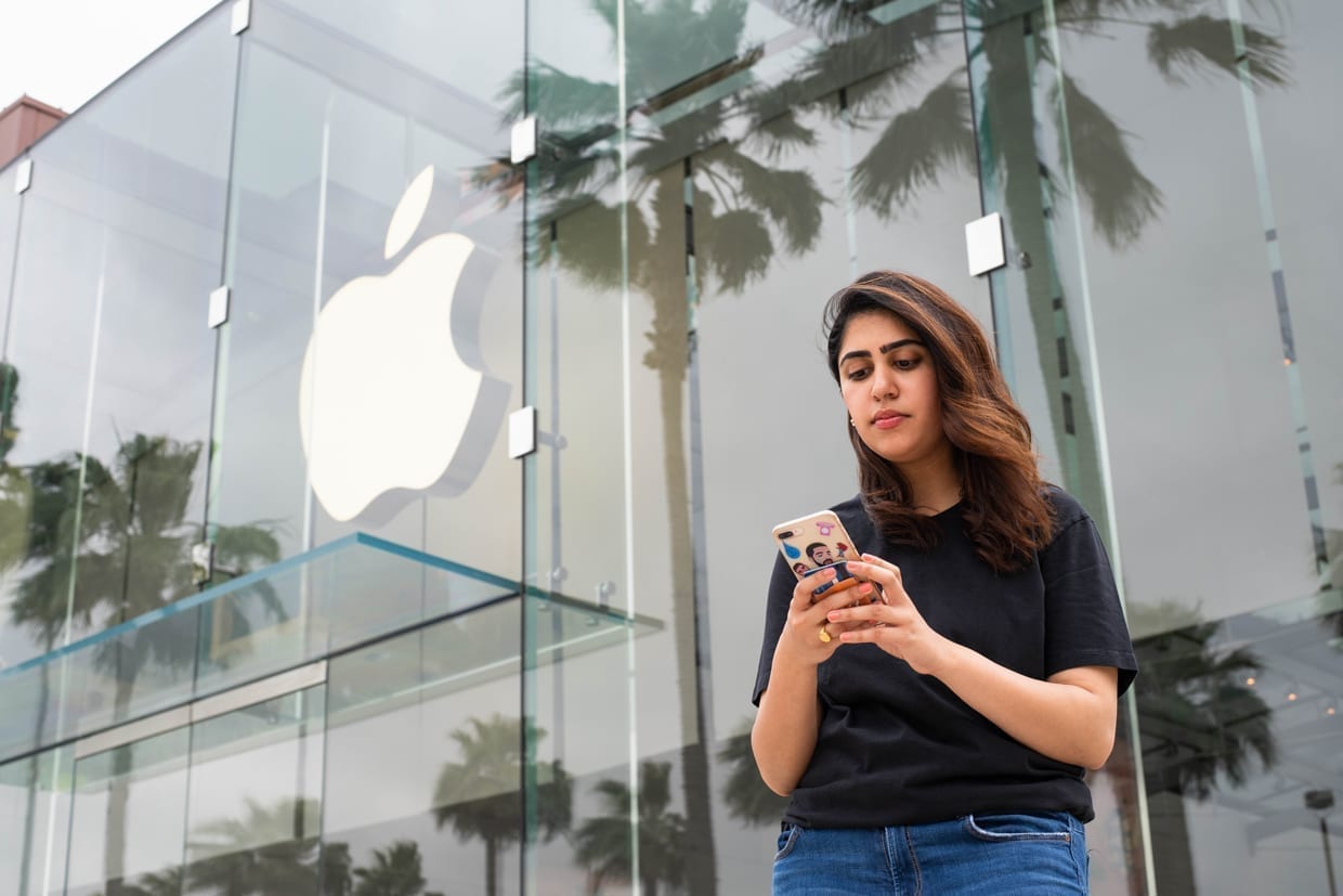 Iman Balagam texts on her iPhone outside an Apple store in Houston.