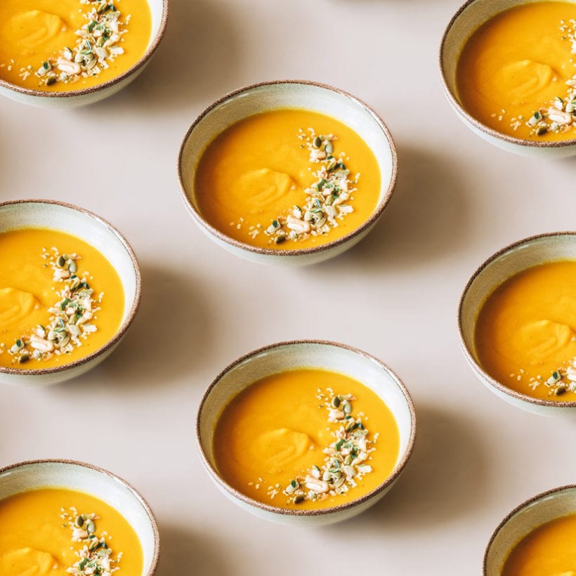 Pumpkin soup topped with herbs, pumpkin seeds and walnuts.