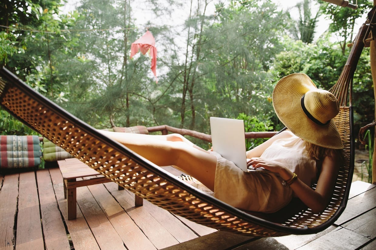 A woman on a hammock with a laptop.