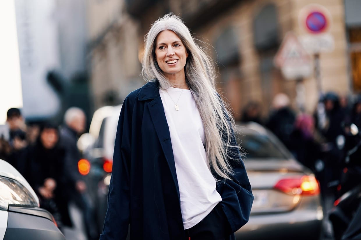 Sarah Harris wears a white t-shirt, a long dark jacket, black pants, white shoes, outside CDG Comme des Garcons, during Paris Fashion Week Womenswear Fall/Winter 2019/2020,March 2, 2019.