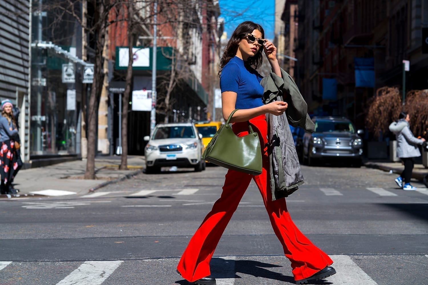 Georgia Fowler wears Khaite pants, an Une Heures top with an Elleme handbag, Bec & Bridge sunglasses and Altuzarra boots in New York City, March 26, 2018.