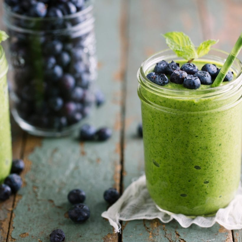 A green mango smoothie topped with fresh, crisp blueberries.