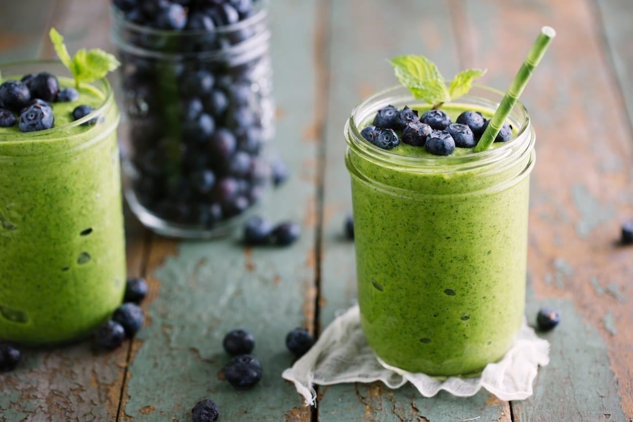 A green mango smoothie topped with fresh, crisp blueberries.