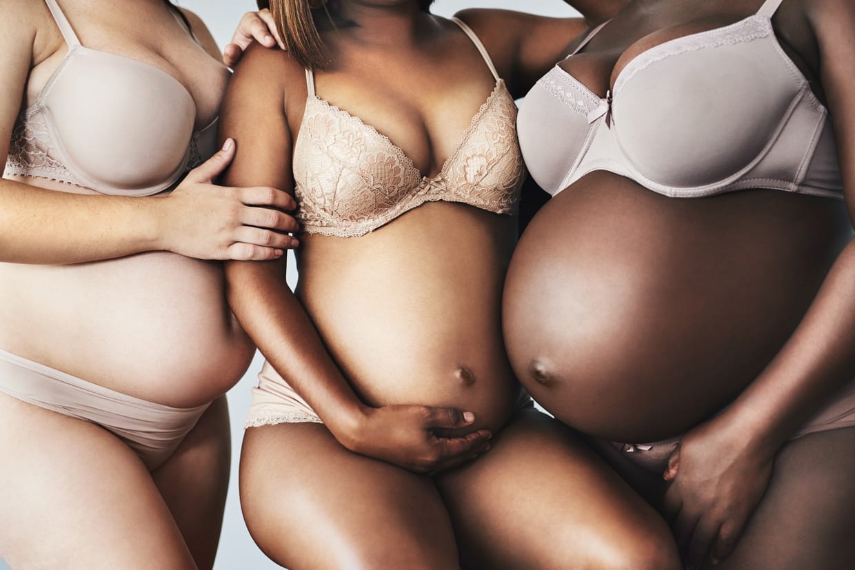 Cropped shot of unrecognizable pregnant women posing together with their hands on their bellies.