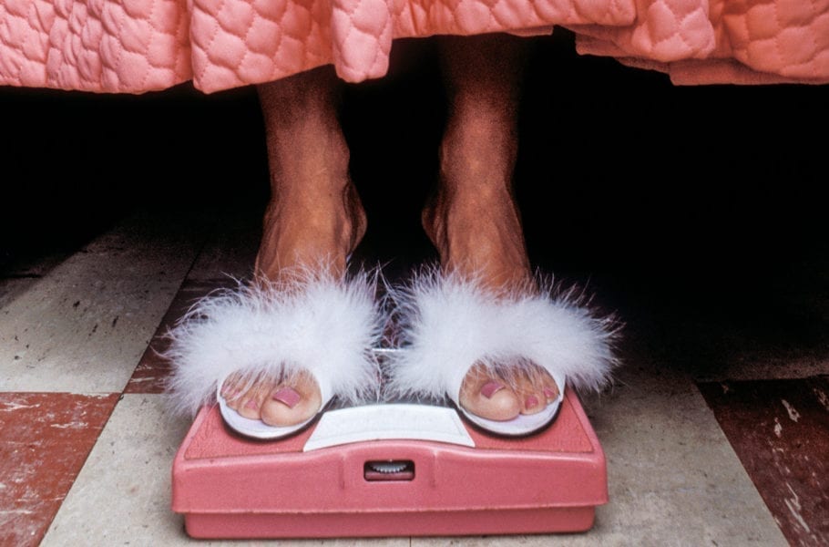 Closeup of someone in white feathered sandals.