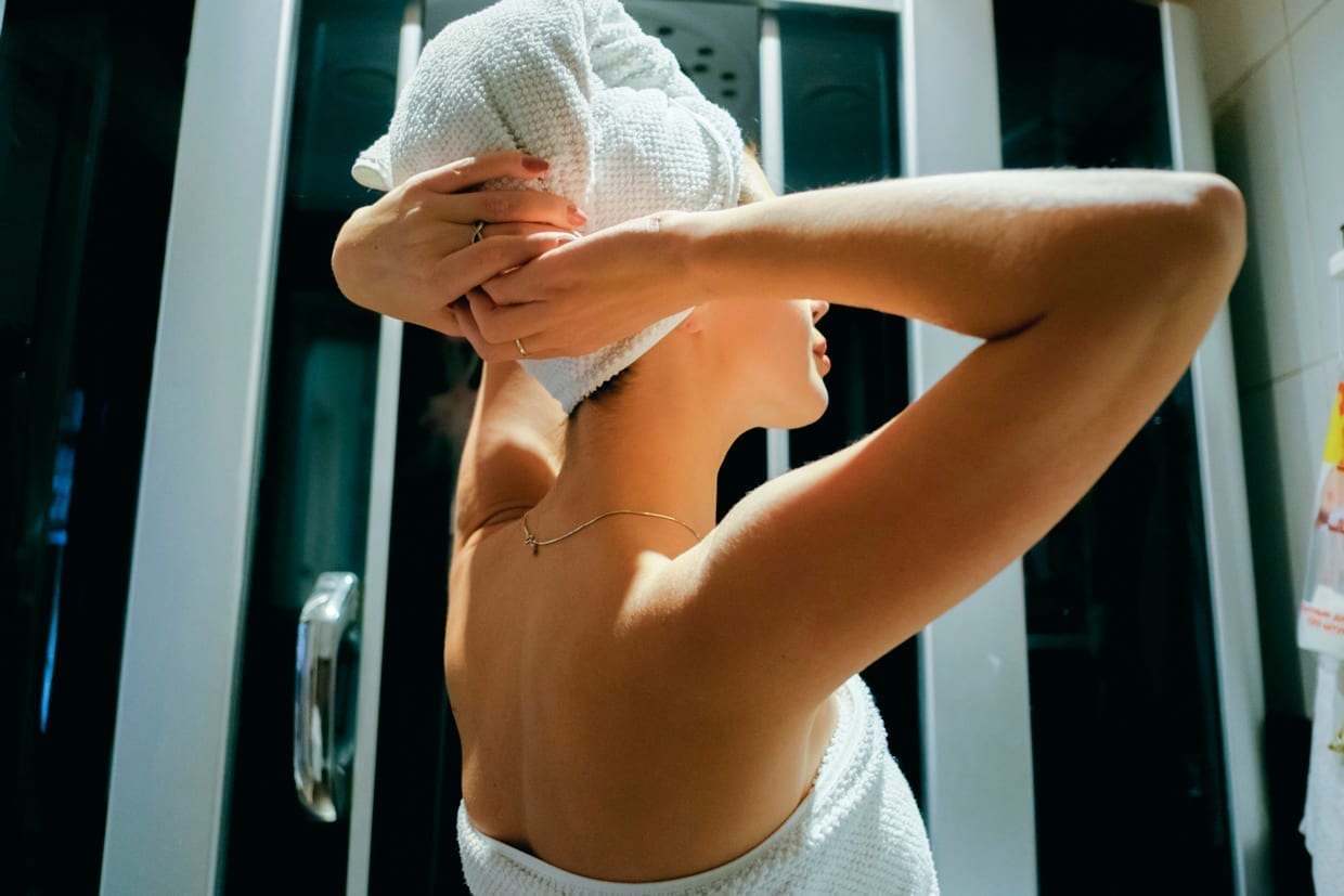 A woman drying her hair with a towel.
