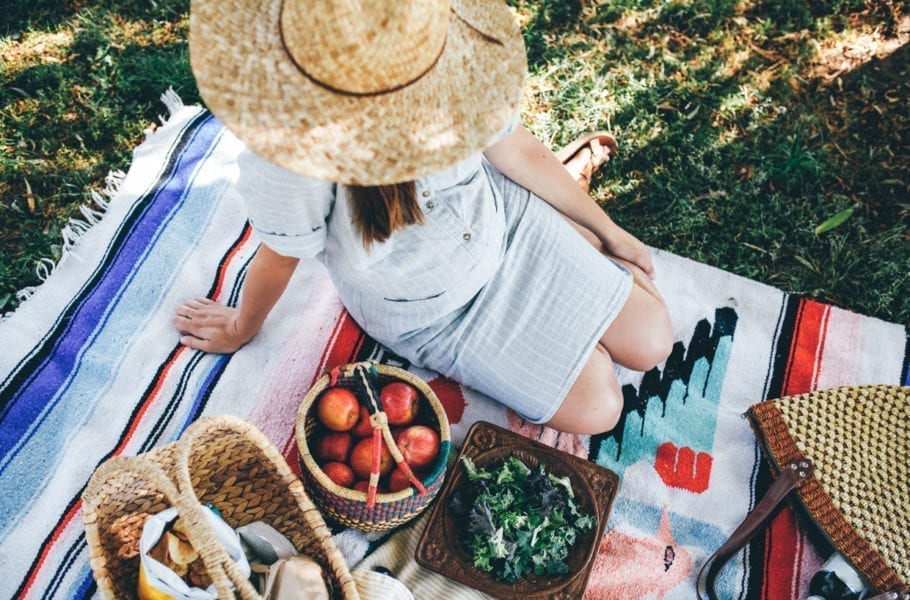 A pregnant woman having a picnic in the park.