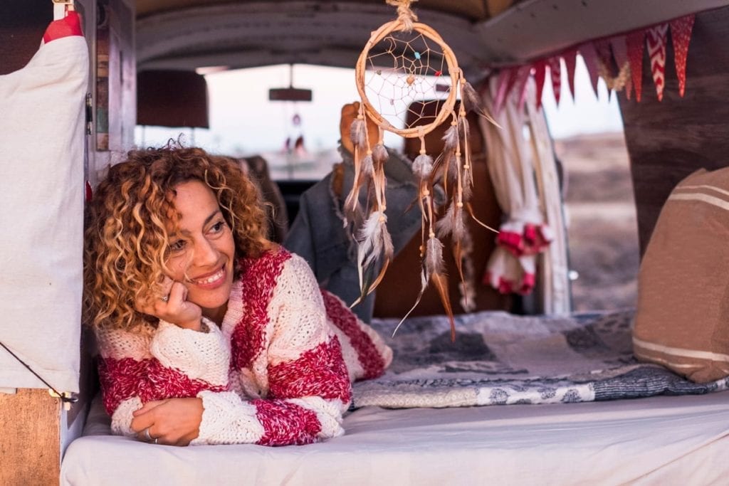 A woman lies next to a dream catcher.