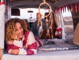 A woman lies next to a dream catcher.