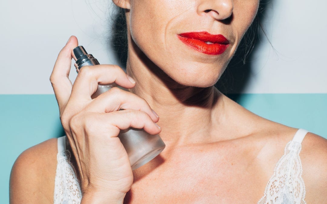 Portrait of a woman in her fifties applying a spray to her skin.