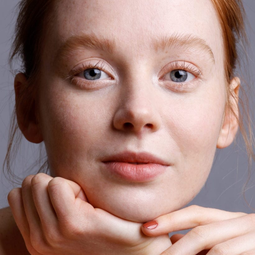 A close up of a young woman with red hair.