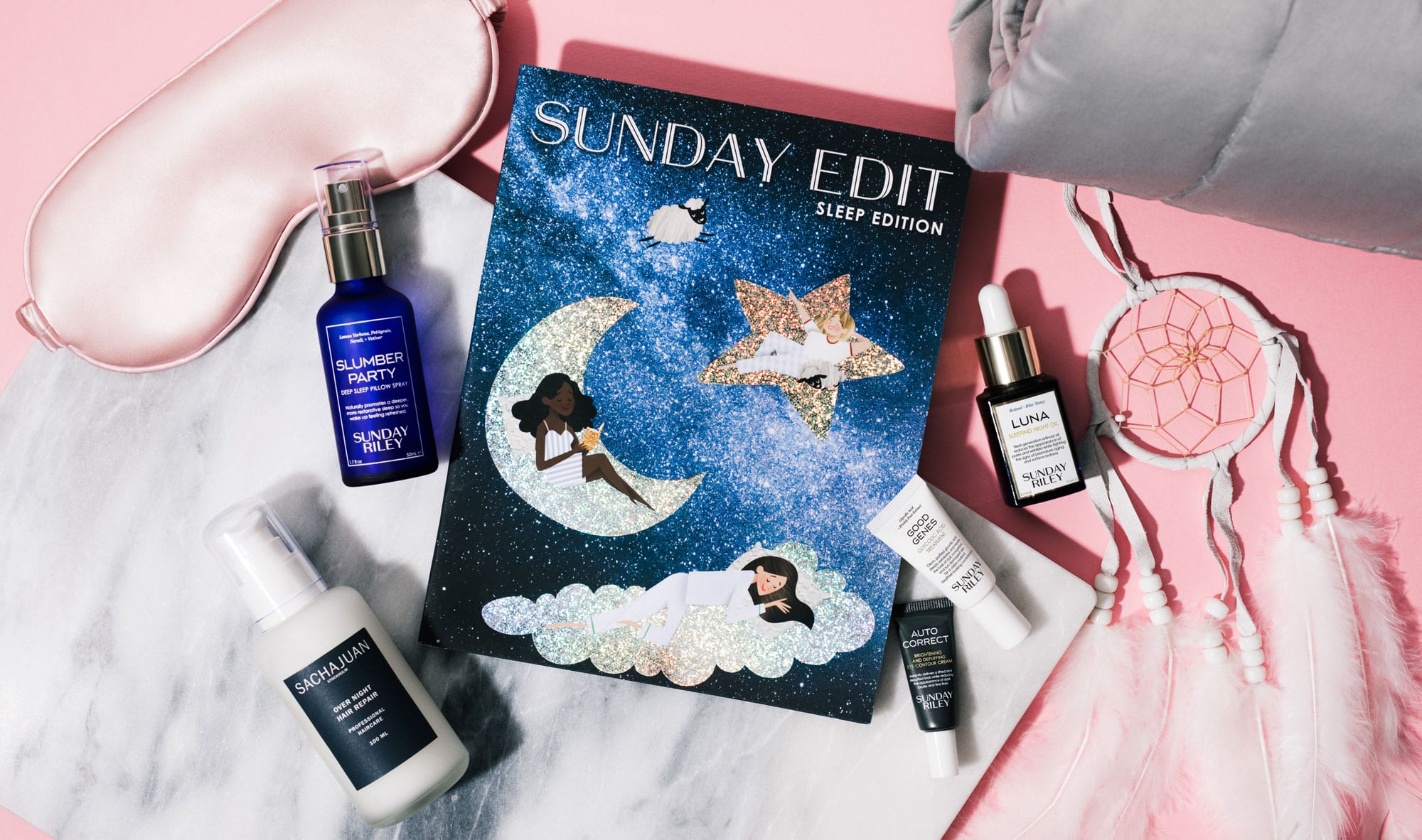 An overhead shot of beauty products, sleep mask, journal, blanket, and dreamcatcher.