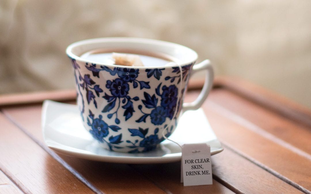 A cup of tea on a wooden table.