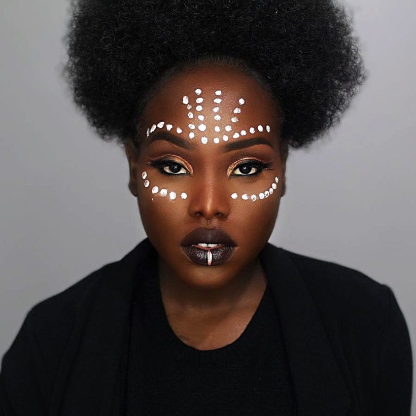A woman with white face paint on.
