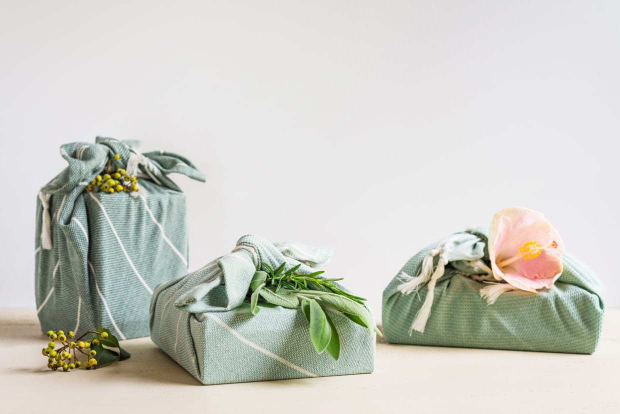 Three gifts wrapped in cotton material.