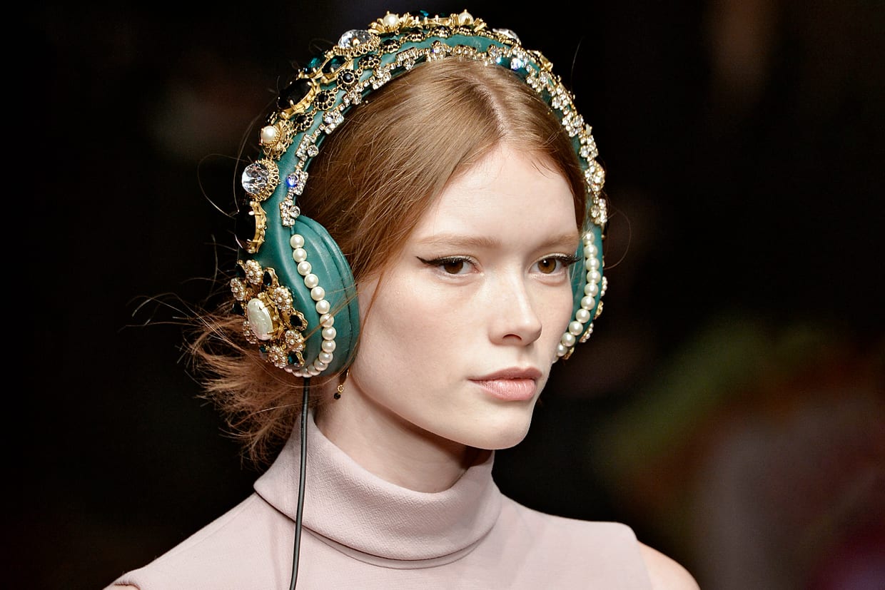 A model wearing green bejeweled headphones walks the runway at the Dolce & Gabbana Autumn Winter 2015 fashion show, March 1, 2015.