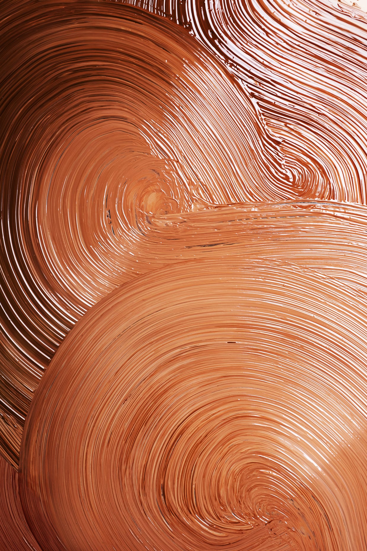 Various shades of liquid foundation in a paint stroke swirl.