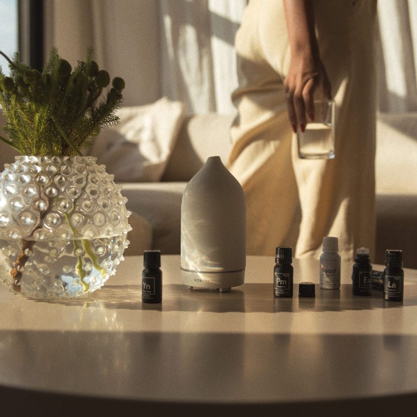 A table with a set of essential oils and a Vitruvi diffuser.