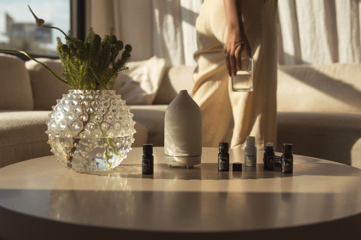 A table with a set of essential oils and a Vitruvi diffuser.