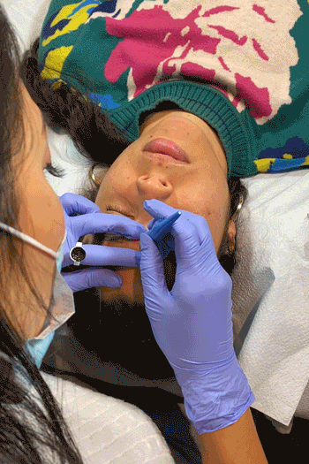 An animated gif of a woman getting her eyebrows microbladed.