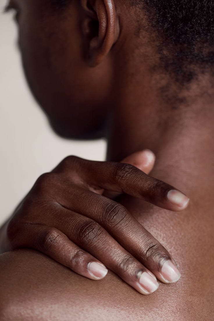 Close up of a woman rubbing her back.