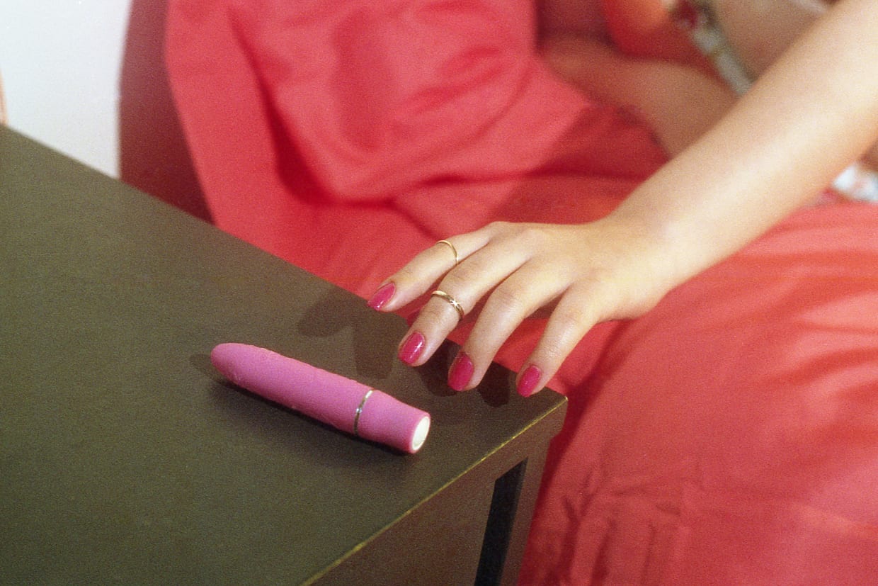 A woman's hand reaching for a vibrator.