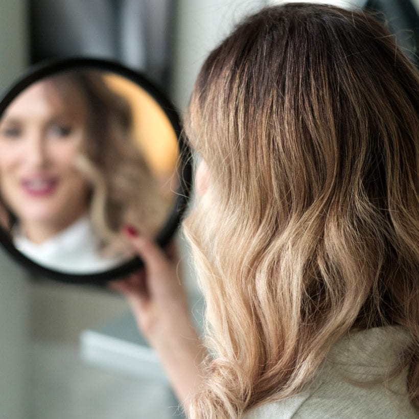 A woman looking at herself in a mirror.