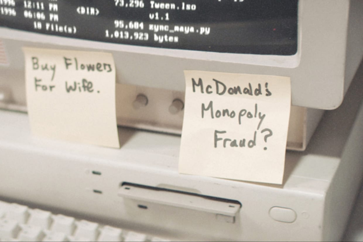 A desktop computer with a sticky note that reads, 'McDonald's Monopoly Fraud?"