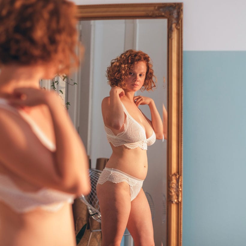 A woman looking at herself in a mirror.
