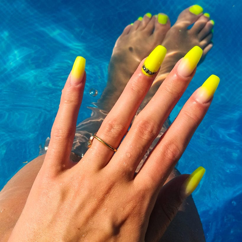Close up of a woman's nails by the pool.