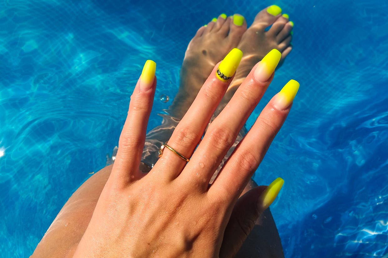 Close up of a woman's nails by the pool.