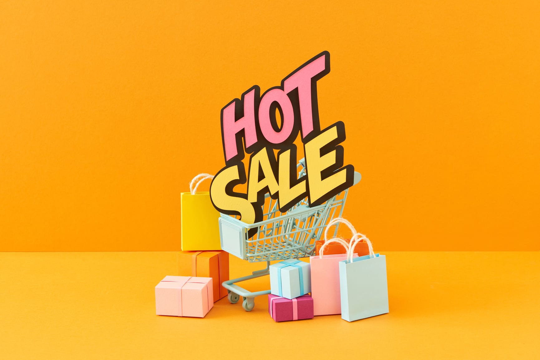 Abstract design element, annual sale, shopping season concept, mini cart with colorful paper bag and word HOT DEAL