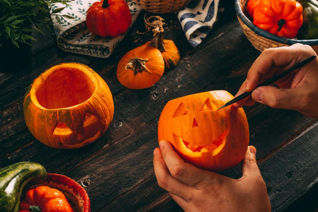 Man Making a Pumpkin Decoration For Halloween