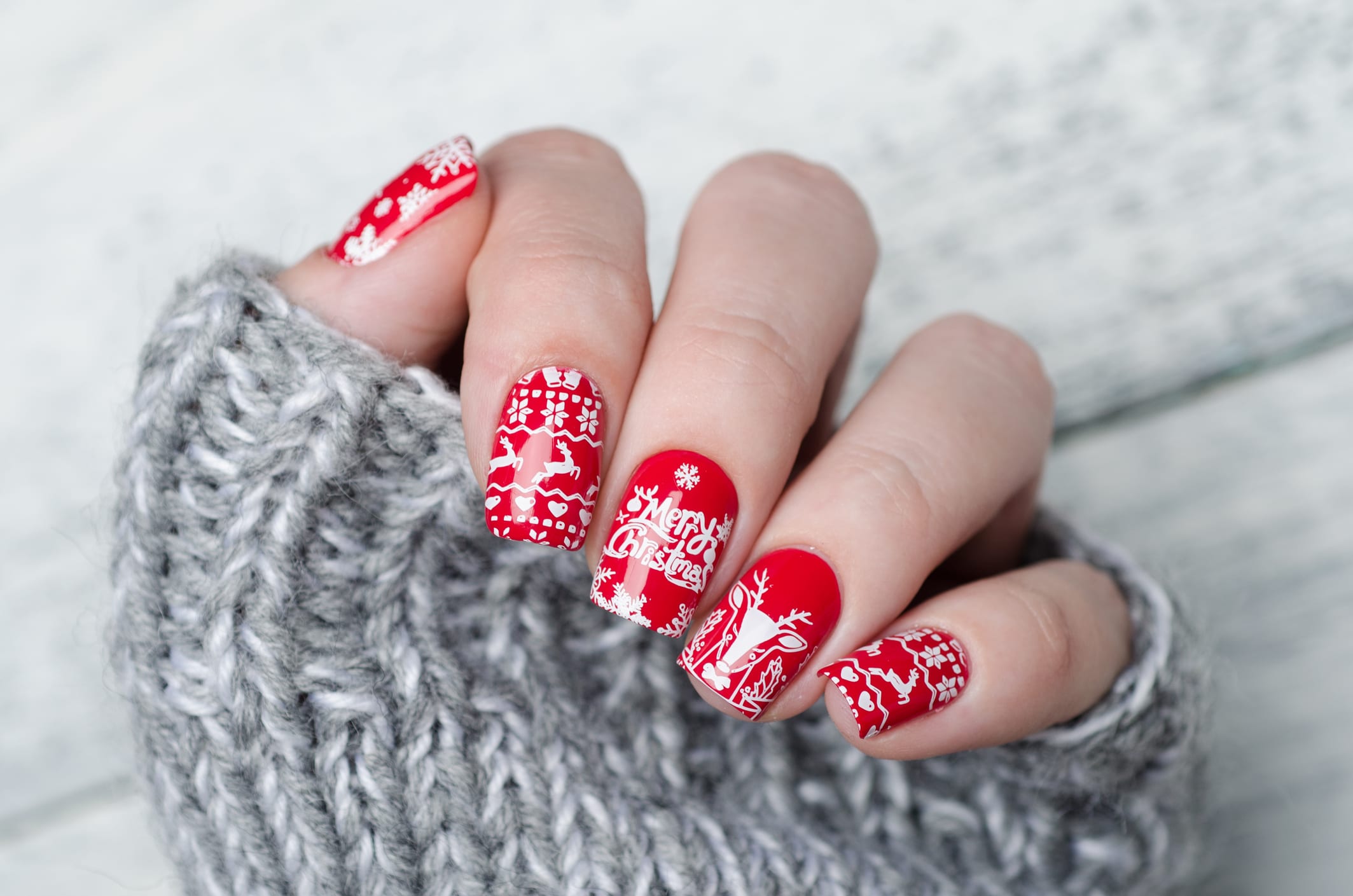 red Christmas manicure with deer and snowflakes and Norwegian pattern