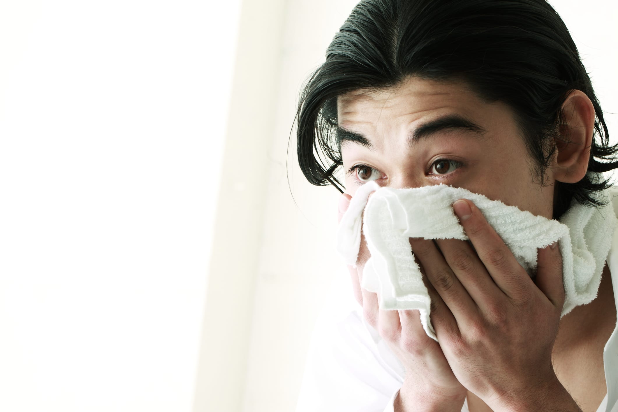 Man using towel to dry face