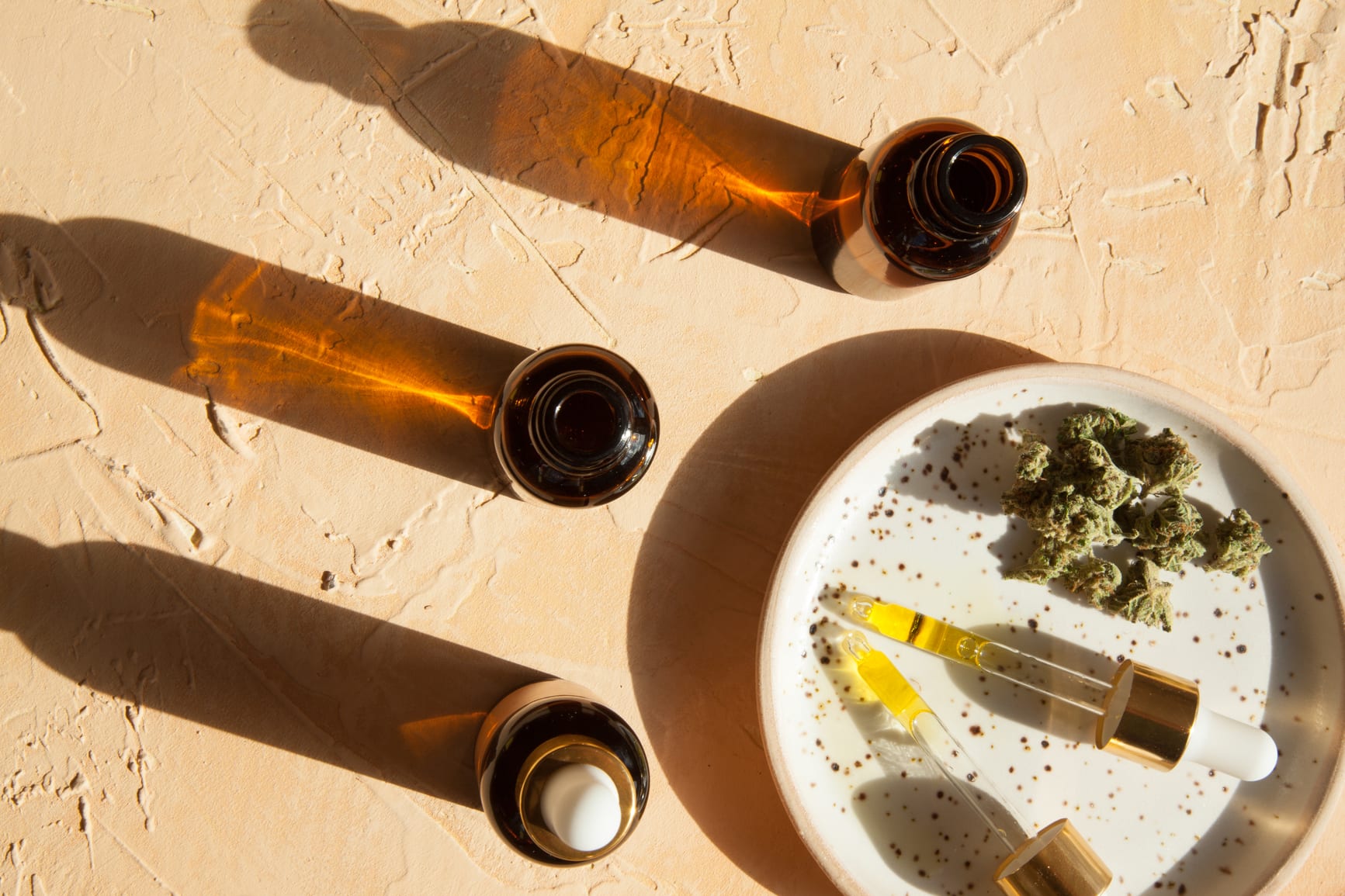 Cbd/cannabis Oil Bottles And Droppers In Sunlight