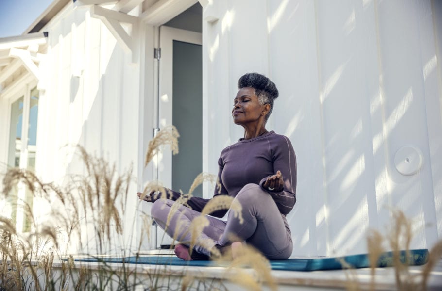 Mature woman meditating in backyard