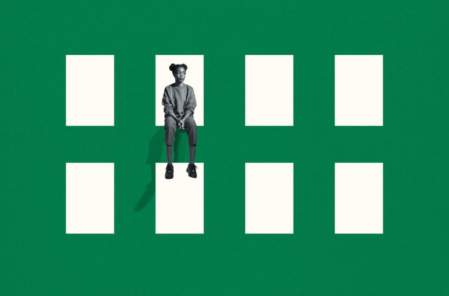 Full length of lonely young woman looking away while sitting on green grid window against white background