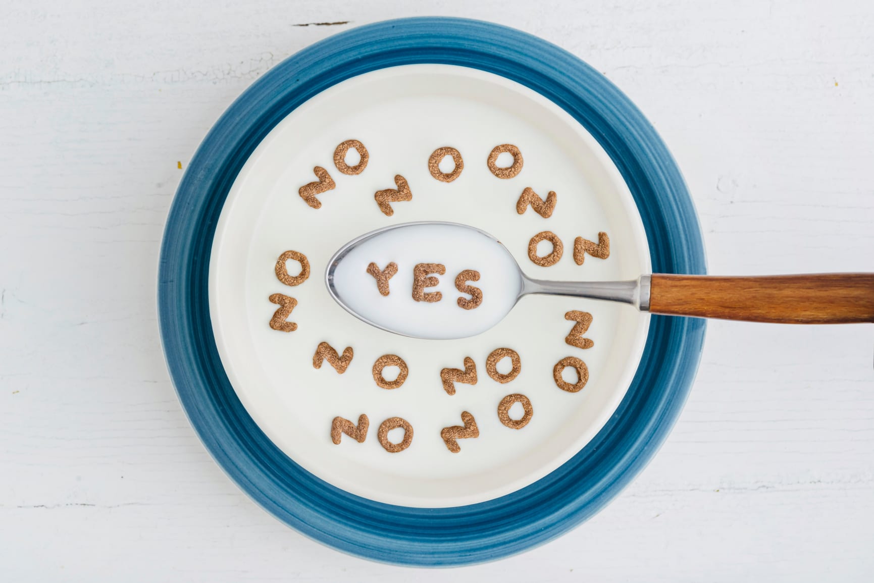 milk bowl with cereals that make the word NO and YES inside the spoon
